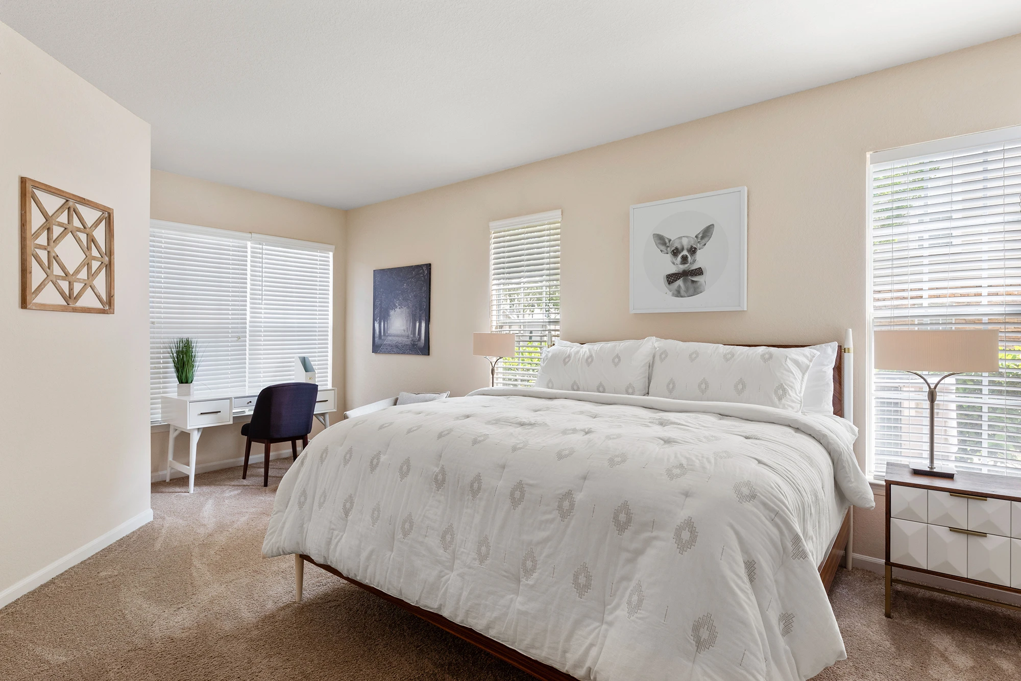 Bedroom with three windows, bed, and desk space.